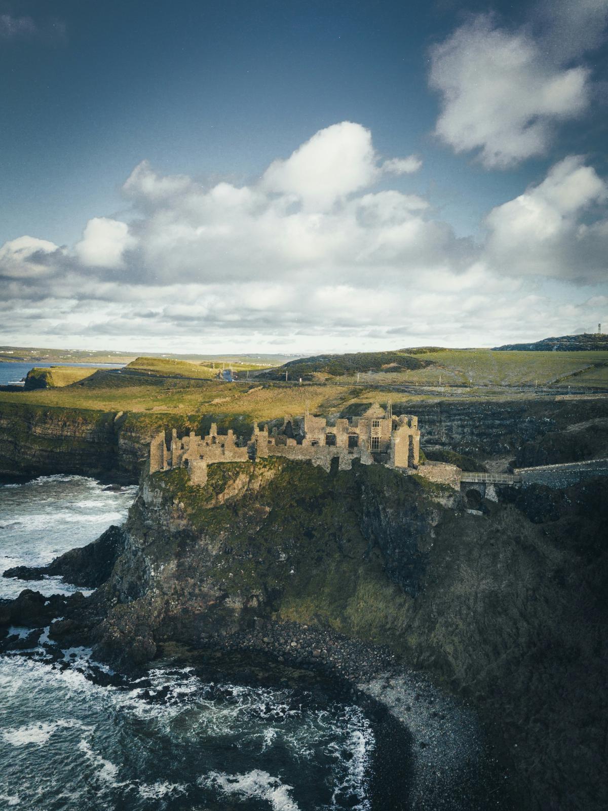 Eine alte Burg an der Küste Irland im Bild von Steije Hillewaert auf Unsplash