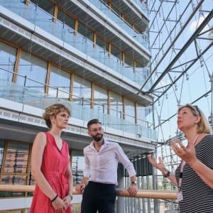 Eine Reiseleiterin erklärt einem Pärchen etwas zum MedienHafen in Düsseldorf