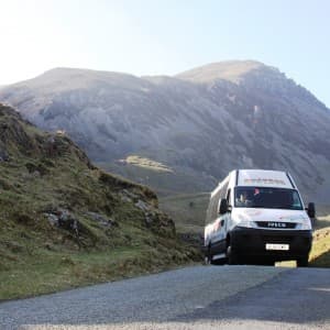 Zwischen den Bergen im Snowdonia Nationalpark fährt ein Kleinbus mit Landausfluggästen
