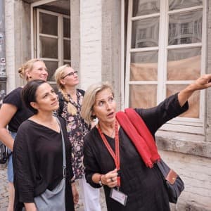 Drei Frauen bekommen etwas von einer Reiseleiterin gezeigt