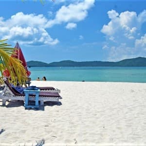 Weißer Sandstrand mit Sonnenliegen und Meer auf Koh Madsum