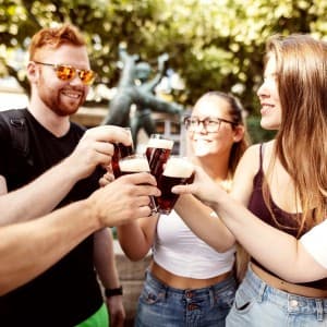 Eine Gruppe von Menschen stoßen bei sonnigem Wetter mit Altbier an