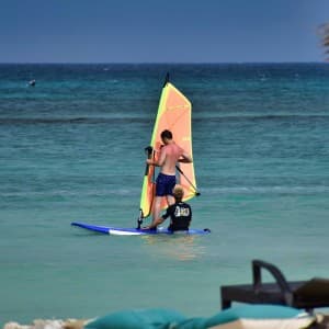 Ein Windsurflehrer gibt seine Tipps zum optimalen Windsurfen an seinen Schüler weiter