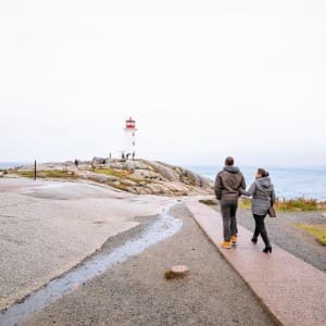 Zwei Passanten gehen zum Leuchtturm Peggy's Point