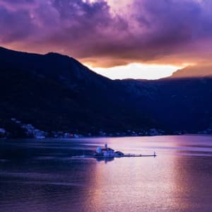 Guests visit the artificially built island "Our Lady of the Rocks" during their boat tour in Kontor