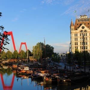 Die Willemsbrug mit ihren leuchtend roten Bögen spiegelt sich im Wasser