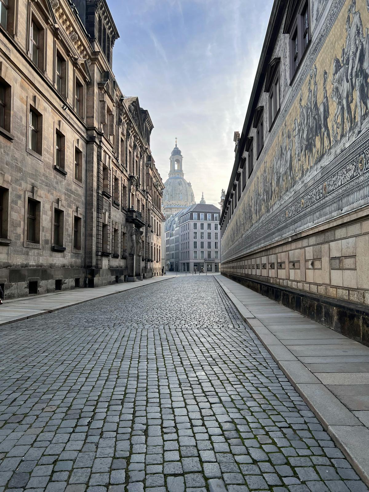 Der Fürstenzug in Dresden mit Blick auf die Frauenkirche im Bild von Bert Sagi auf Unsplash