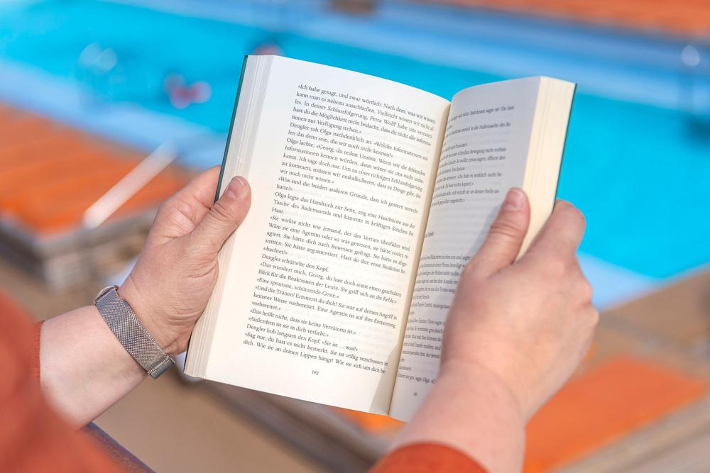 Eine Person liest ein Buch auf einem Kreuzfahrtschiff